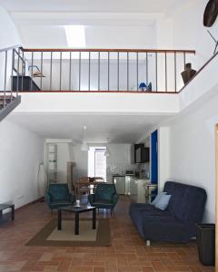 古勒冈Quinta dos Álamos Agroturismo的客厅配有蓝色的沙发和两把椅子