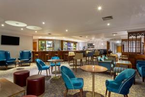 查塔姆Bridgewood Manor Hotel & Spa的一间设有蓝色桌椅的餐厅和一间酒吧