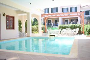 米里纳艾菲斯酒店的一座带白色椅子的别墅内的游泳池