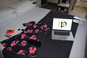 米兰佩鲁吉诺酒店的一张带手提电脑的连衣裙的床