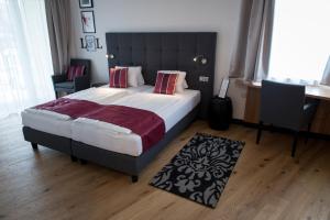 Sankt Ruprecht an der Raab洛克尔和莱杰尔酒店的一间卧室配有一张大床和黑色床头板