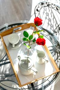 雅典Athens Manor Houses的一张玻璃桌,上面有两朵玫瑰花