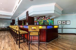 哈博罗内克雷斯塔总统酒店 的一间酒吧,房间内设有椅子和墙上的绘画