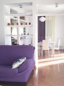 阿尔戈多纳莱斯ATICO-PLAZA的一间带紫色沙发的客厅和一间餐厅