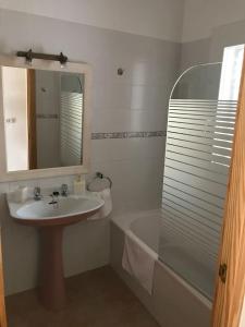 拉萨维纳Casa S Estany的浴室配有盥洗盆、镜子和浴缸