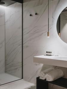 希洪El Môderne Hotel的浴室设有白色大理石墙壁和水槽
