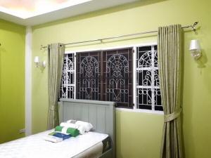 梭桃邑Single House Sattahip的一间卧室设有窗户和一张带毛巾的床。