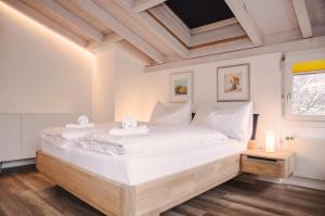 龙疆House Lakeside – GriwaRent AG的一间卧室配有一张带白色床单的大床