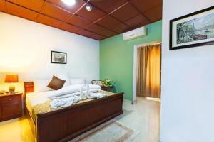 库马西Okumah Hotel的一间设有床铺的卧室,位于一个拥有绿色墙壁的房间