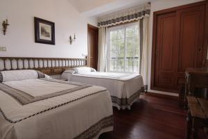 比韦罗埃斯阿雷亚斯一号酒店的一间卧室设有两张床和窗户。