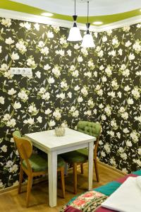 库塔伊西HOSTEL LOOK的一张餐桌和椅子,配有花卉壁纸