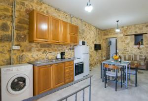 马鲁拉斯Veranda Apartment的厨房配有木制橱柜、洗衣机和烘干机
