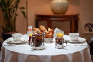 巴黎亚特兰蒂斯酒店的一张桌子,上面有白色的桌布,上面有羊角面包和橙汁