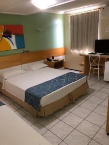 福塔莱萨拉约德索尔普拉亚酒店的一间卧室配有一张床、一张桌子和一台电脑
