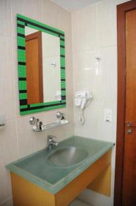 圣保罗全家酒店的一间带绿色水槽和镜子的浴室