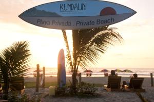蒙塔尼塔Hotel Kundalini的海滩上的一个标志,人们坐在椅子上