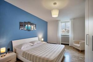 瓦尔玛德雷拉COZY LAKE COMO APARTMENTS的一间卧室设有一张床和蓝色的墙壁