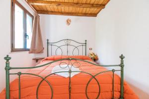 多尔加利Rifugio Gorropu的一间卧室配有一张带橙色棉被的床