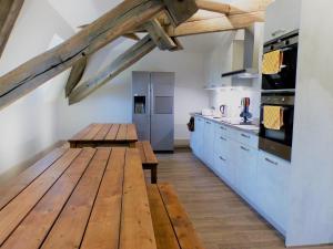 帕雷·勒·毛尼尔La Maison Verneuil的厨房配有木桌和冰箱。