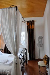 AdaneroCasa rural La sastreria de Adanero的一间卧室配有一张带窗帘和桌子的床