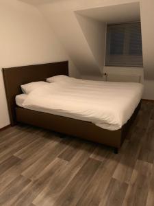 德吕嫩Vakantie huisjes Duinrand Drunen的铺有木地板的小客房内的一张床位