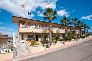 罗哈莱斯Hotel Costa Blanca Rojales的棕榈树街道上的酒店