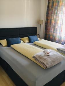 施韦比施哈尔Appartement 29/1的一间卧室配有两张带蓝色和黄色枕头的床
