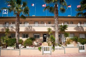 罗哈莱斯Hotel Costa Blanca Rojales的前面有棕榈树的酒店