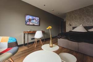 杜伊斯堡尼特龙公寓和酒店的卧室配有1张床、1张桌子和1把椅子