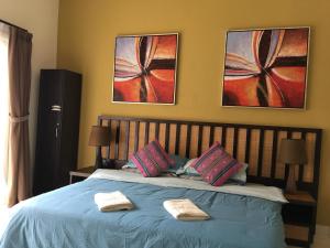 万津Happy Stay @ Morib Gold Coast的一间卧室配有蓝色的床和2条毛巾