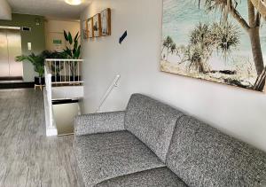 黄金海岸奥特雷格伯利度假村的客厅设有一张灰色沙发,靠墙