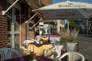 特罗斯多夫普利姆勒酒店的室外咖啡厅配有桌椅和遮阳伞