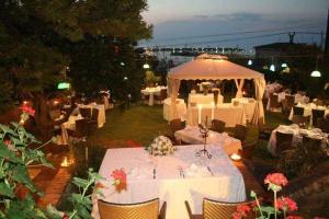 维博瓦伦蒂亚码头B&B Villa Delle Rondini的一间设有白色桌子和白色遮阳伞的餐厅