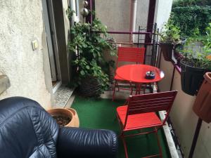 莱比锡Mitten in Leipzig Wohnung 1的庭院配有两把椅子和一张红色桌子