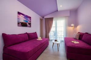 利迈纳里亚GiRene Apartments的紫色的客厅配有沙发和桌子