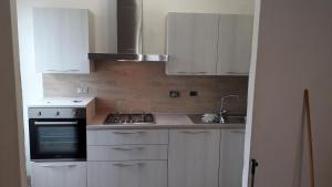 切齐纳码头Appartamento a Cecina mare的厨房配有白色橱柜和炉灶烤箱。