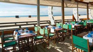 维拉摩拉Beach Apartment Marina Vilamoura的海滩上的餐厅,配有桌椅