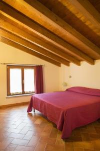 卢尼贾纳自由镇CASA VACANZA VILLA DeA的一间带红色床的卧室,位于带木制天花板的房间内