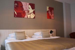 布拉格1共和国酒店的卧室配有一张墙上有两张照片的床。