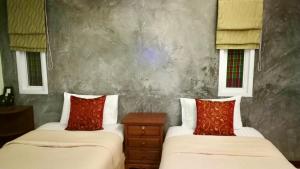 查龙佩内帕小木屋的客房内的两张床和红色枕头