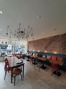 阿姆斯特丹嗨耶130酒店 的一间带桌椅的餐厅以及砖墙