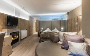 圣莱奥纳尔多因帕西里亚Stroblhof Active Family Spa Resort的酒店客房配有床、沙发和电视。