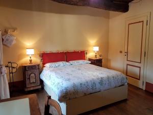 Borgo TicinoB&B La Cascina di Monia e Mario的一间卧室配有一张床,两盏台灯放在两张桌子上