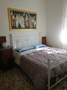 阿斯蒂Oasi di tranquillità的卧室配有一张床,墙上挂有绘画作品