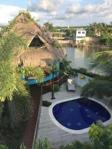 卡塔赫纳Hotel Palmera Beach Cartagena的茅草屋顶和游泳池的度假村
