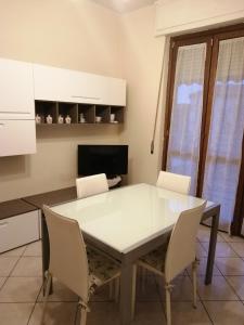 阿斯蒂la casa di fiore的厨房配有白色的桌椅