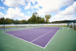 Saint-Sylvestre-sur-Lot斯特西亚酒店的网球场,上面有两顶网球网