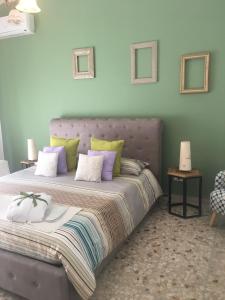 锡拉库扎Siracusa Vacanze的一间卧室配有一张大床,提供紫色和绿色枕头