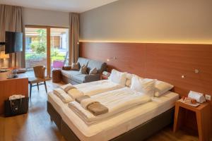 莱赫阿尔贝格阿尔卑斯山附近莱赫住宿加早餐旅馆的一间卧室配有一张大床和木制床头板