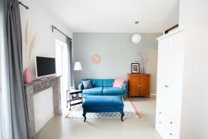 马格德堡ElbQuartier Apartments Magdeburg 'Die Stadtoase'的客厅配有蓝色椅子和电视